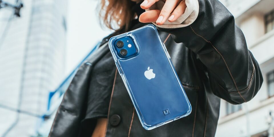 woman in black leather jacket holding blue iphone case